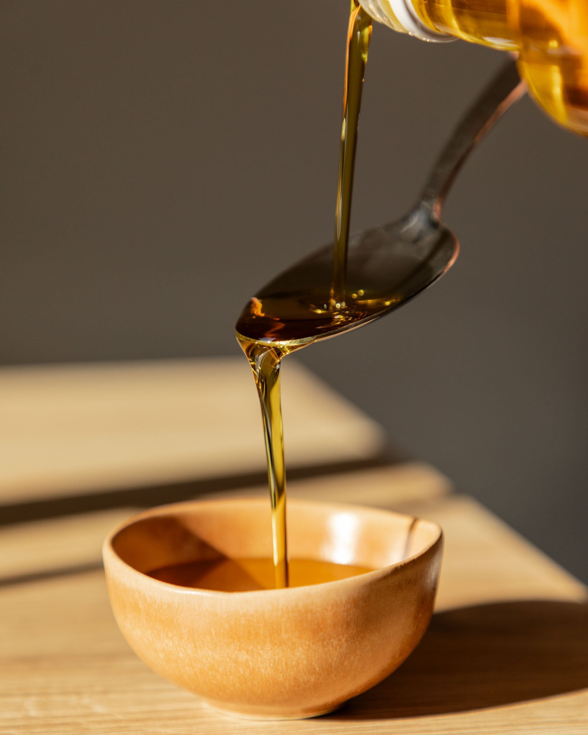 Huile d'olive versée dans un bol en bois